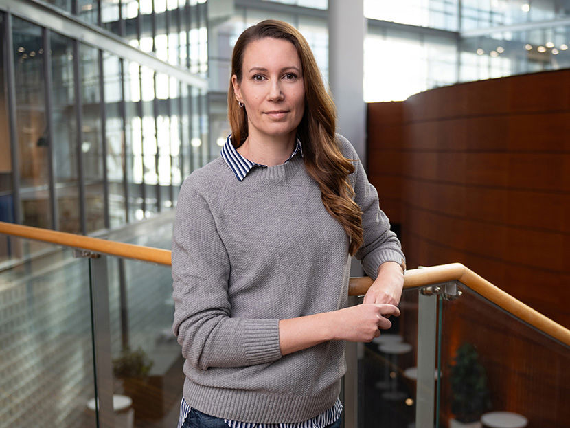 Asiantuntija katsoo kameraan toimistoympäristössä